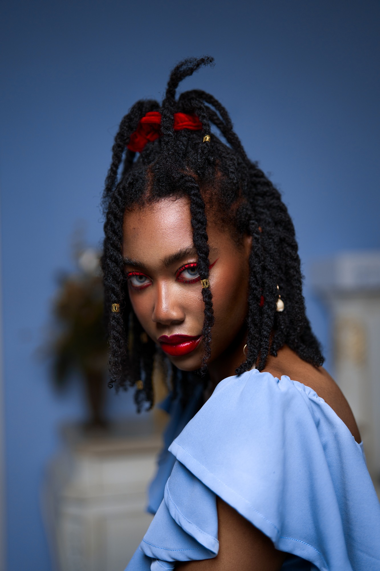 EfikZara looking over her shoulder with natural twists and a blue outfit
