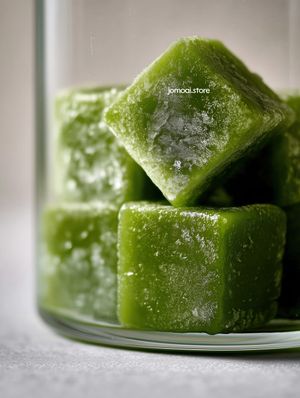 Macro frozen matcha green tea cubes in glass