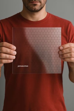 Man holding transparent hexagon-patterned acrylic sheet