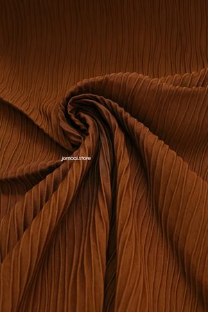 Textured brown pleated fabric with elegant swirl