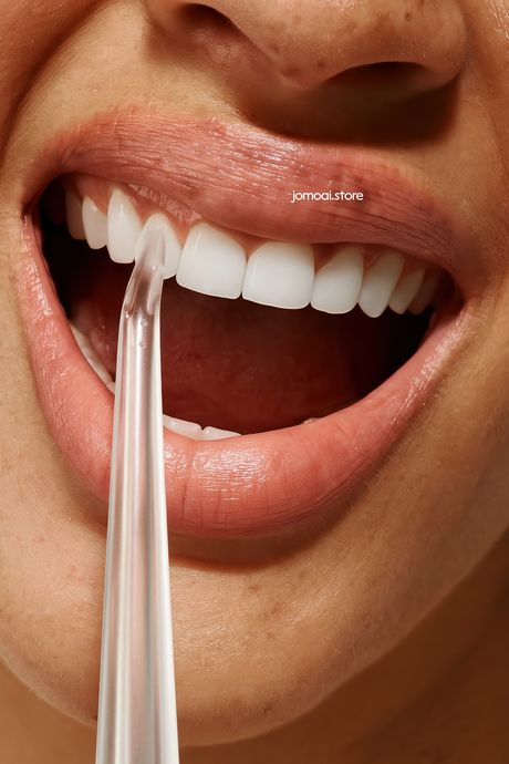 Close-up of a perfect white smile with irrigator