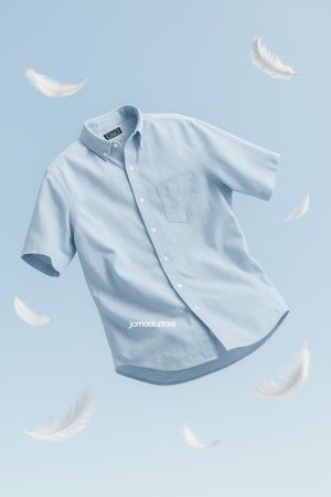 Floating Blue Shirt Surrounded by Feathers – Lightweight Cotton Garment in Motion