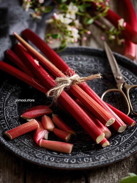 Fresh Rhubarb Stalks Tied With Twine On Rustic Plate