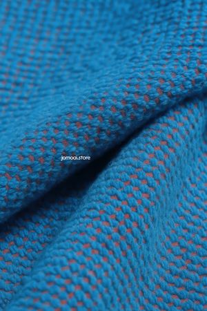 Blue woven fabric texture with red underlay close-up