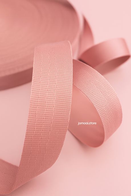Close-up of pink textured ribbon on pastel background