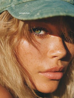 Extreme Close-Up Portrait of Woman in Cap with Freckles and Sunlight