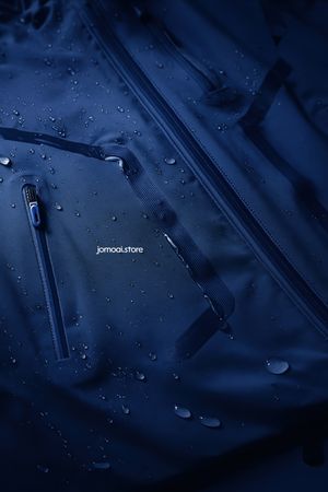 Dark blue waterproof jacket with sealed zippers and droplets