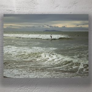 Surfer Riding Ocean Wave at Sunset with Distant Island Horizon Photo Download