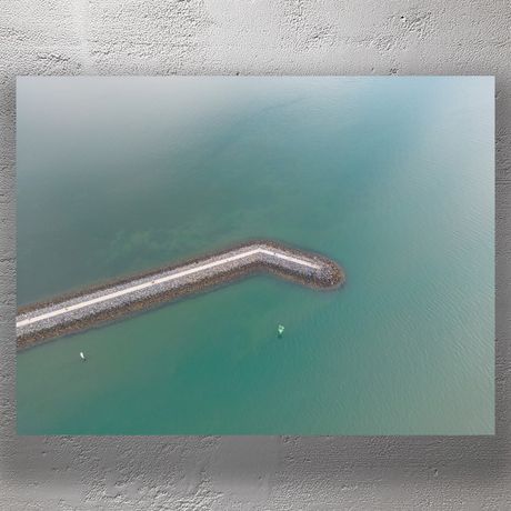 Curved Seawall Aerial View Over Calm Ocean Waters Photo Download