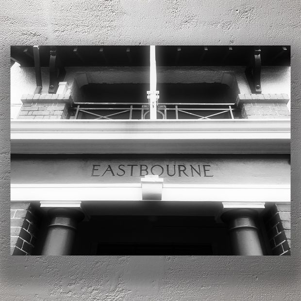 Historic Building Entrance with Eastbourne Signage Black and White Architectural Photo Download
