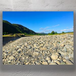 Rocky Riverbank Landscape Tranquil Nature View with Blue Sky and Green Hills Photo Download