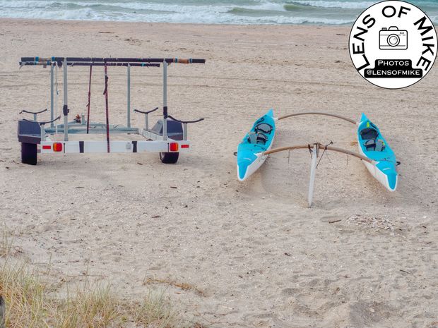 Twin Outrigger Canoes on Sandy Beach with Trailer by the Ocean Photo Download