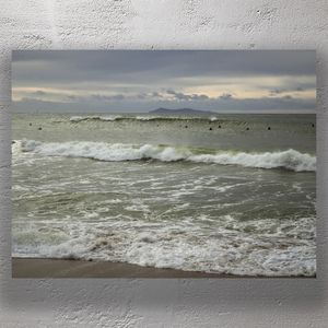 Surfers Waiting for Waves on a Moody Ocean Shoreline at Dusk Photo Download