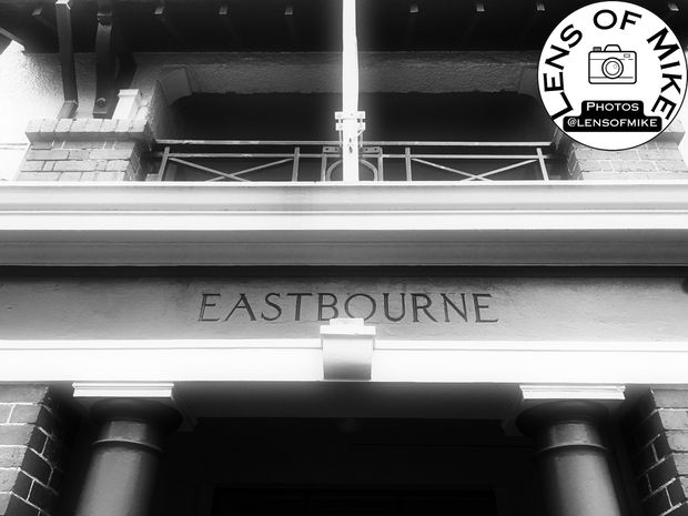 Historic Building Entrance with Eastbourne Signage Black and White Architectural Photo Download
