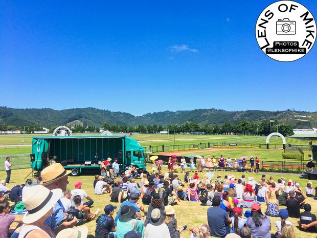 Vibrant Outdoor Event at Trentham Racecourse Crowds Stage and Scenic Backdrop Photo Download