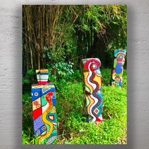 Vibrant Hand-Painted Totem Poles in Lush Tropical Garden Photo Download