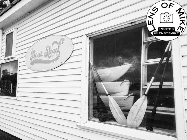 Vintage Boat Shed Exterior with Canoes and Paddles Photo Download