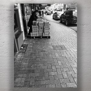 Urban Street Logistics Man Leaning on Fragile Packages Photo Download