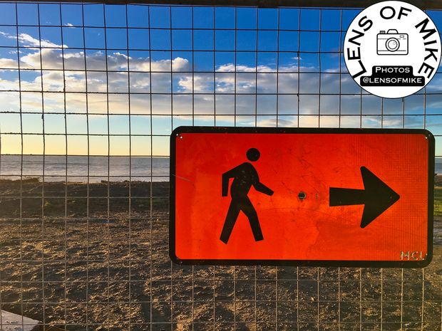 Bright Orange Pedestrian Sign Against Coastal Sunset Directional Walkway Photo Download