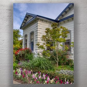 Charming Historic Building with Vibrant Flower Garden Under Blue Sky Photo Download