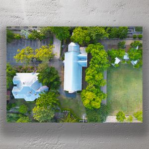 Aerial View of Historic Church with Metal Roof Surrounded by Lush Greenery Photo Download