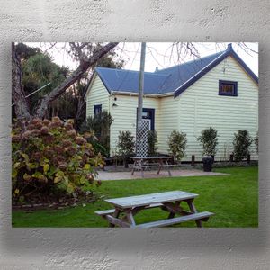 Charming Yellow Cottage with Garden Picnic Area and Autumn Foliage Photo Download
