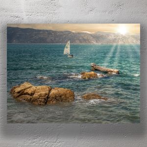 Serene Coastal Escape Sunlit Sailboat and Rocky Shoreline Photo Download