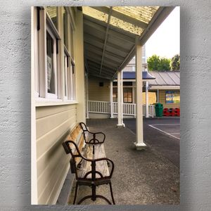Quiet School Courtyard with Wooden Bench Under Covered Walkway Photo Download