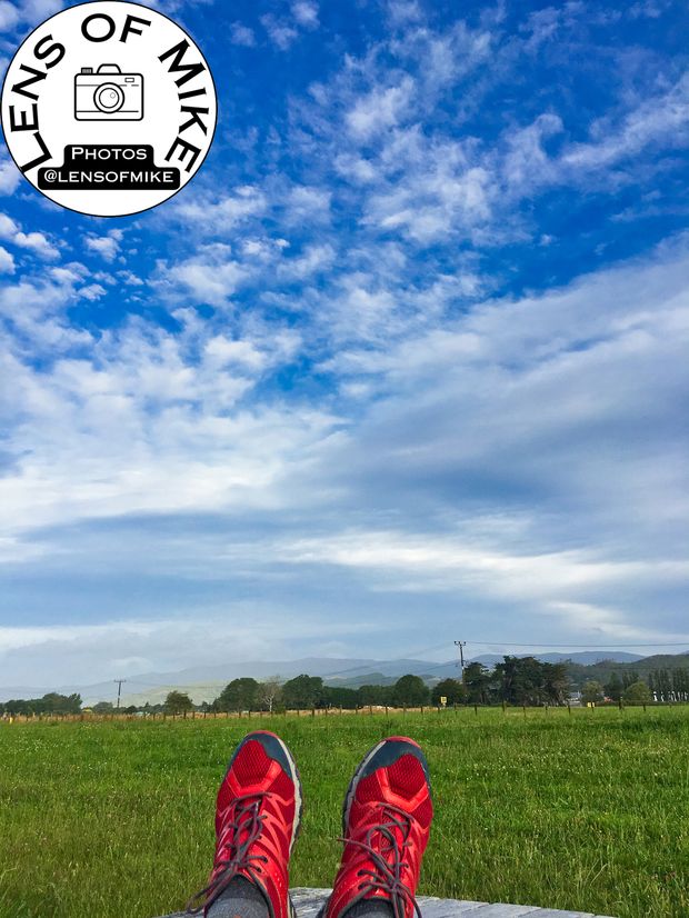 Relaxing Outdoors Feet Up with Red Running Shoes Against a Scenic Blue Sky Photo Download
