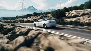 Electric car drive on the wind turbines background. Car drives along a mountain road