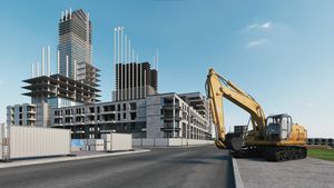 Houses construction process.  Excavator on the background of a construction site