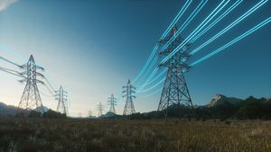 High voltage steel power pylons in field. Transmission of electricity through high-voltage wires