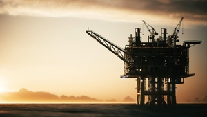 Silhouette of an oil platform in the ocean at sunset