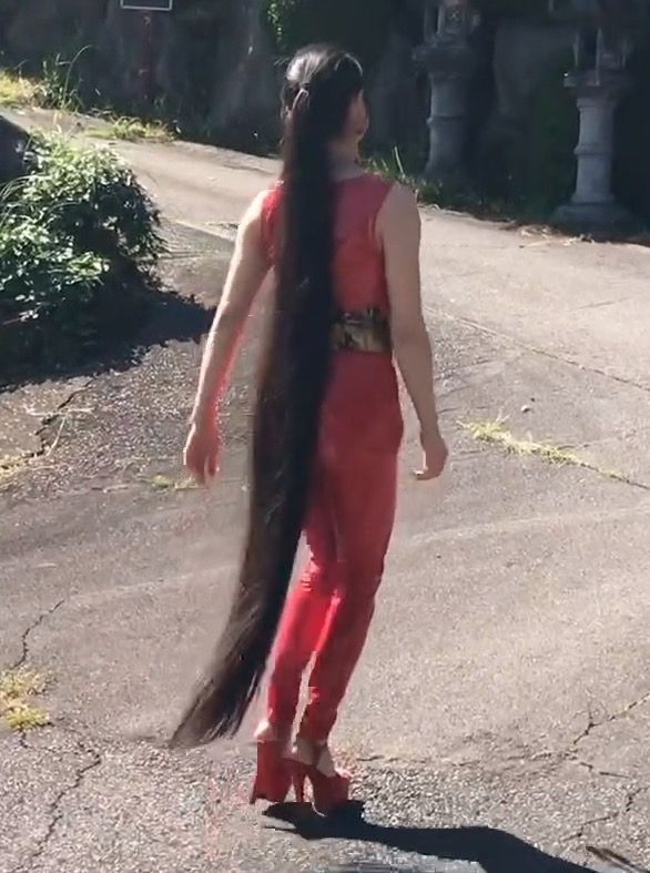 VIDEO - Very long black hair and a red suit