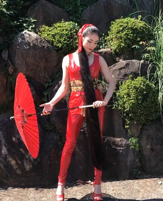VIDEO - Very long black hair and a red suit