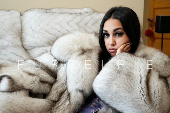 Gigi in blue fox fur coat on a couch (164)